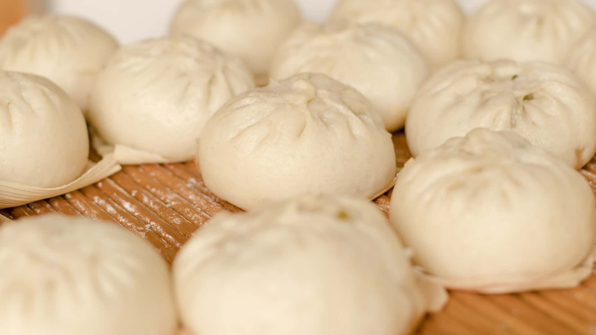 Dumplings cuits à la vapeur disposés sur une surface en bambou, favorisant les bienfaits sur la santé digestive grâce aux ferments lactiques.