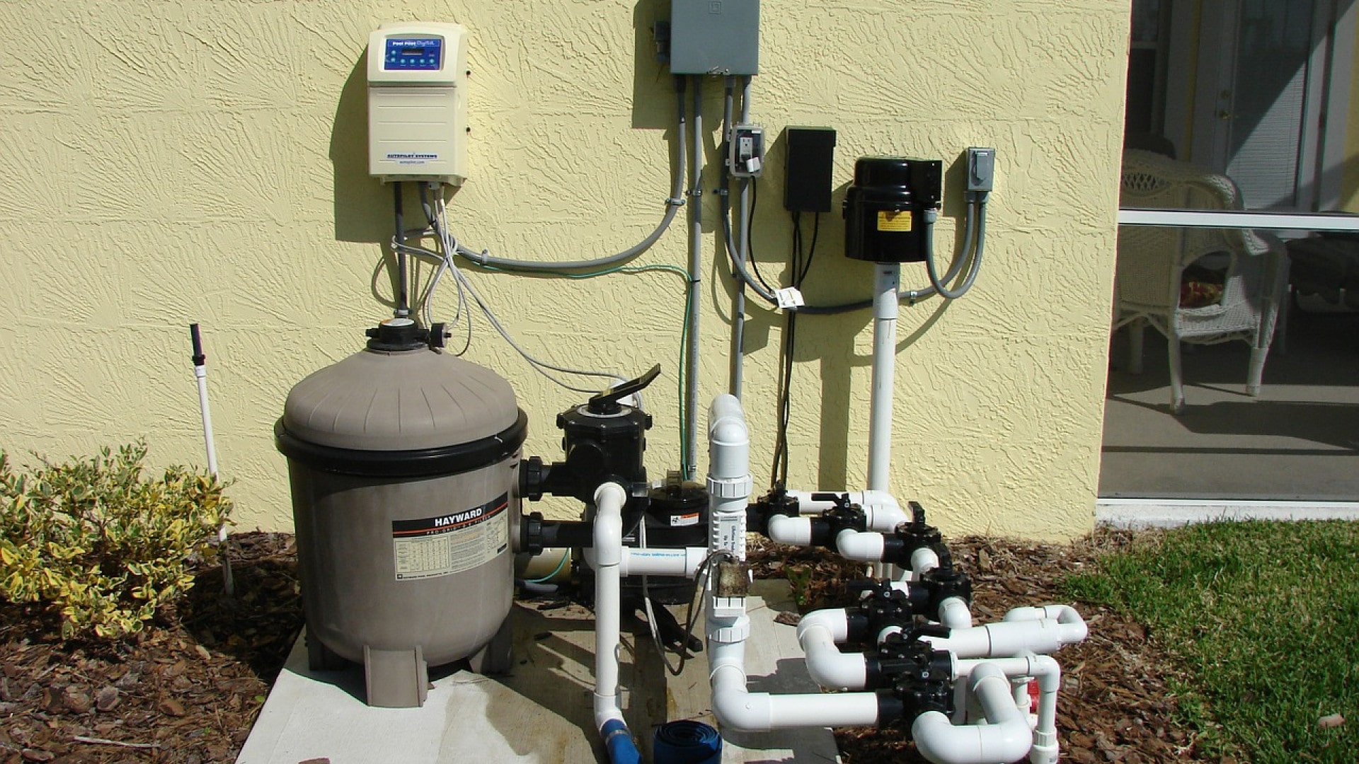 Pompe de piscine résidentielle et système de filtration avec unités de contrôle montées sur mur extérieur pour une meilleure qualité de l'air.
