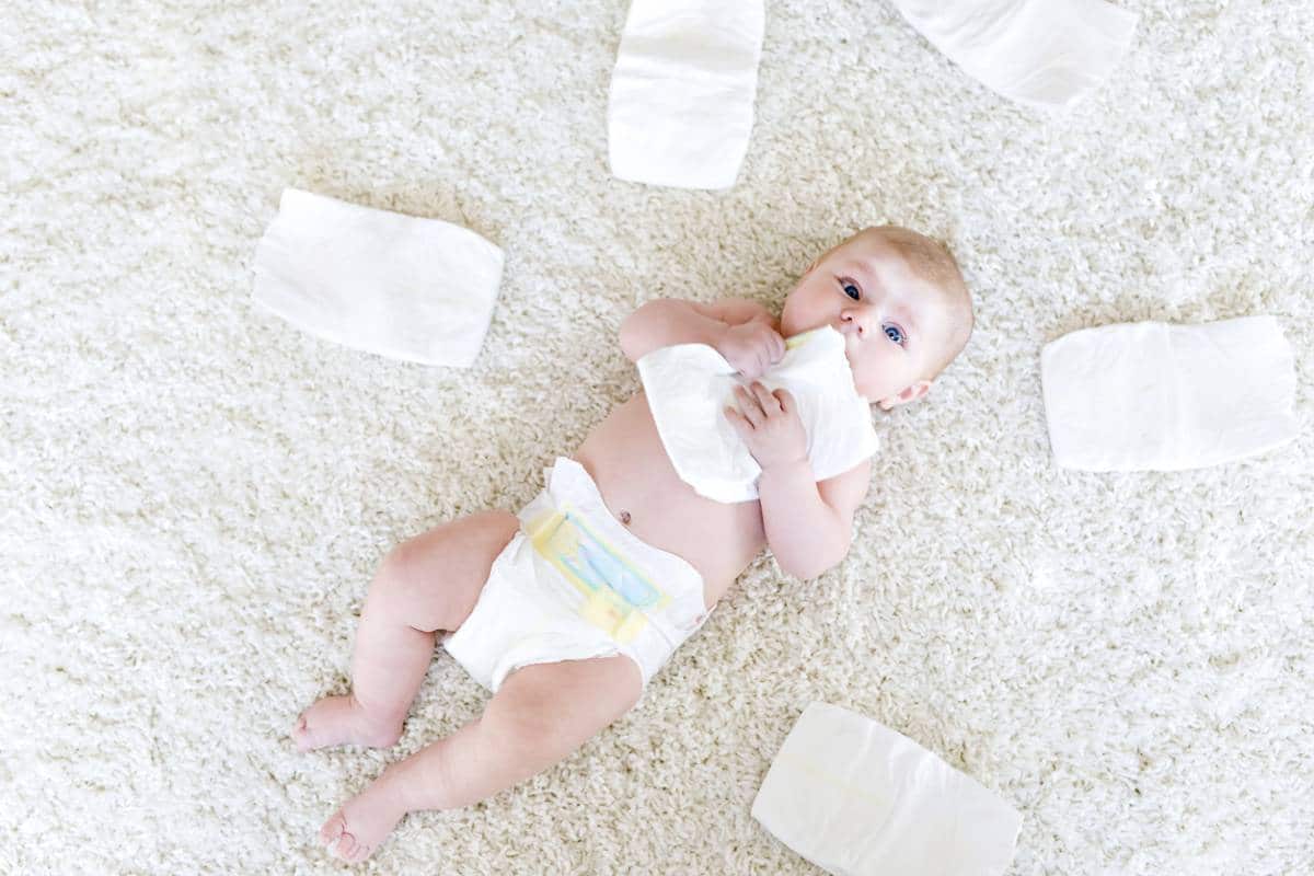 Un bébé allongé sur un tapis entouré de couches peut avoir un impact sur la santé en raison des matériaux utilisés dans les canapés pour bébé.