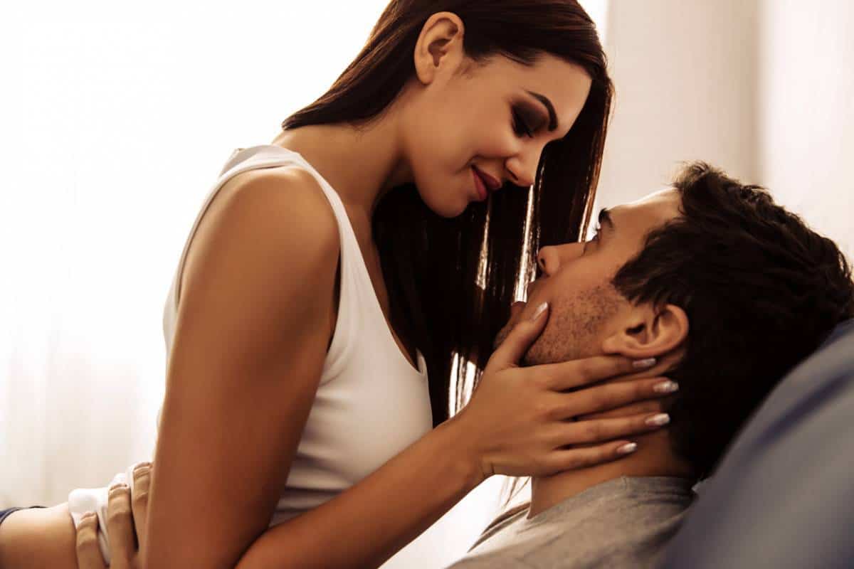 Un couple partageant un moment d'intimité, malgré l'impuissance sexuelle de l'homme, avec la femme lui tenant tendrement le visage.