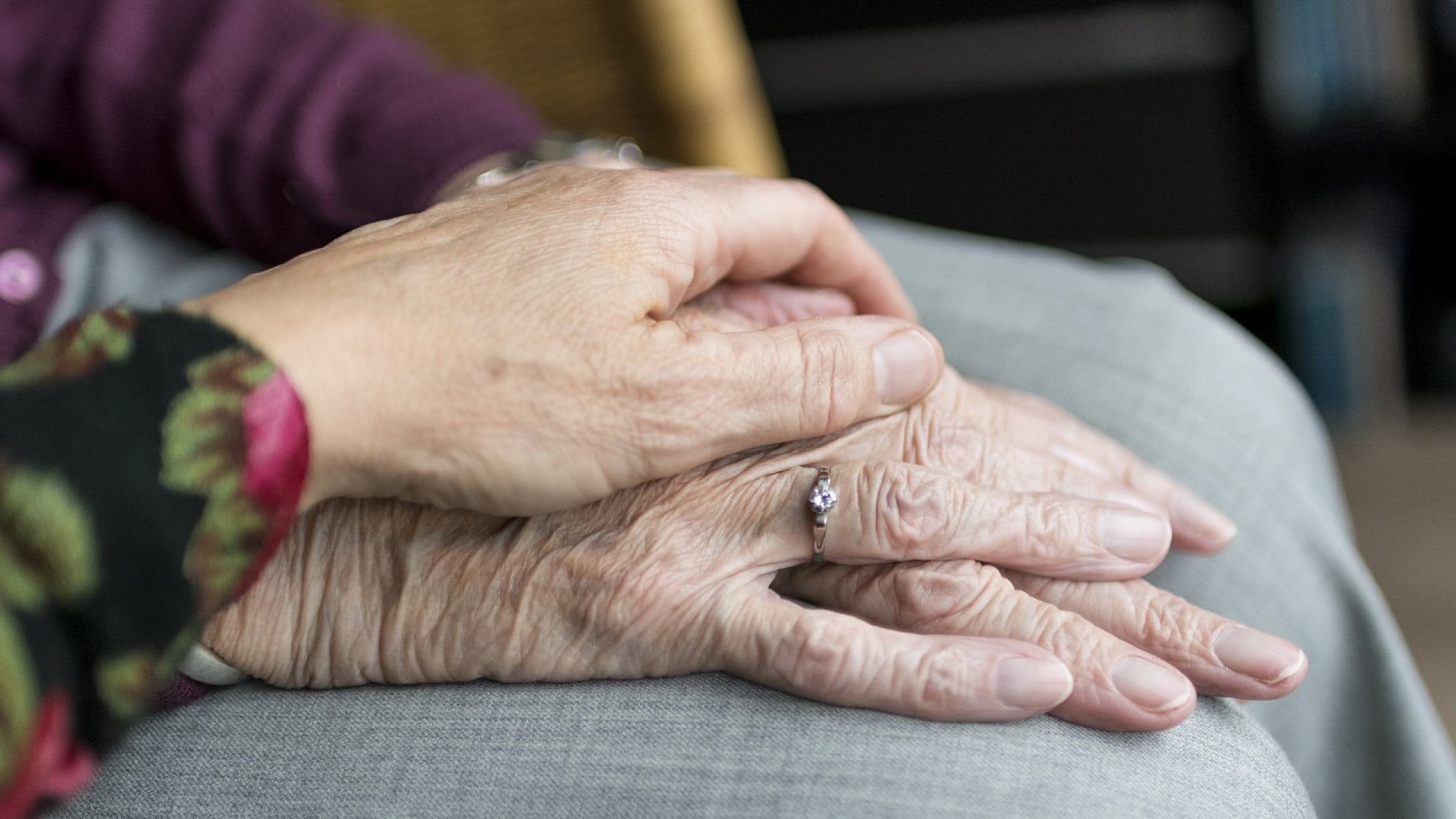 Gros plan sur les mains d'une personne âgée montrant des signes de vieillissement et portant une bague.