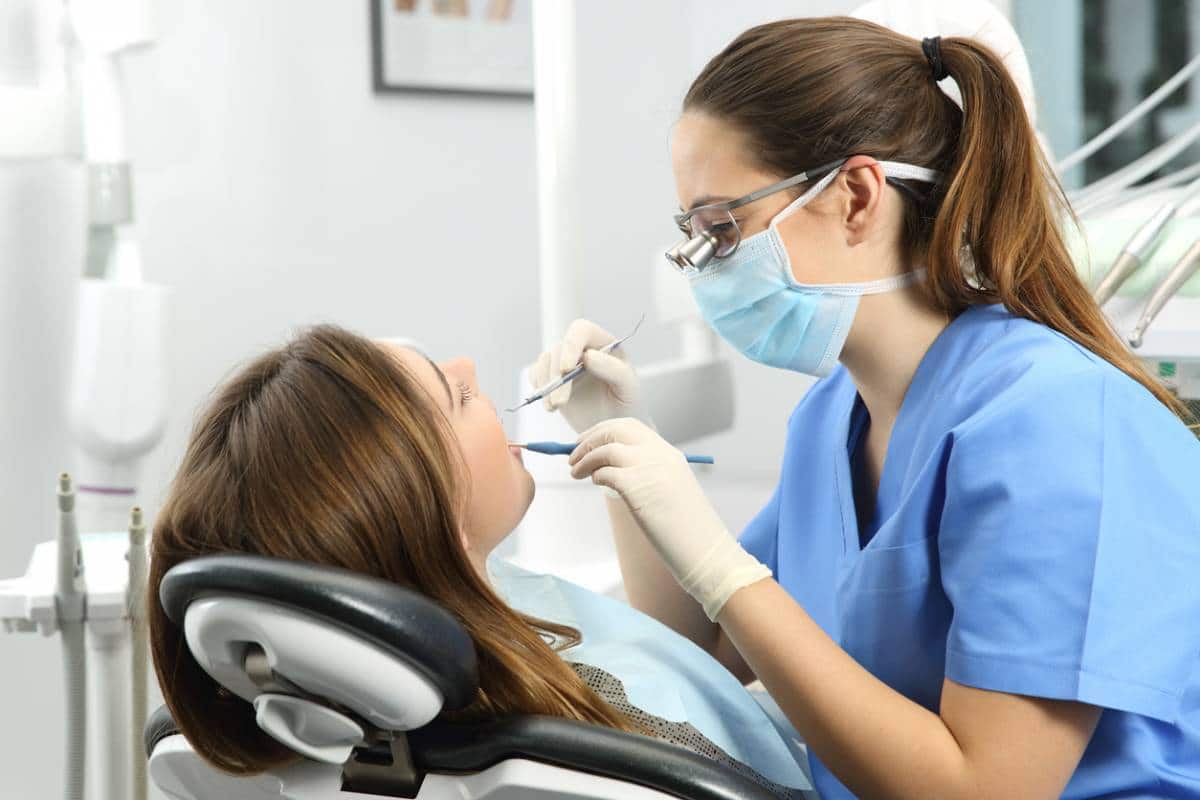 Dentiste effectuant un examen dentaire sur un patient dans une clinique.