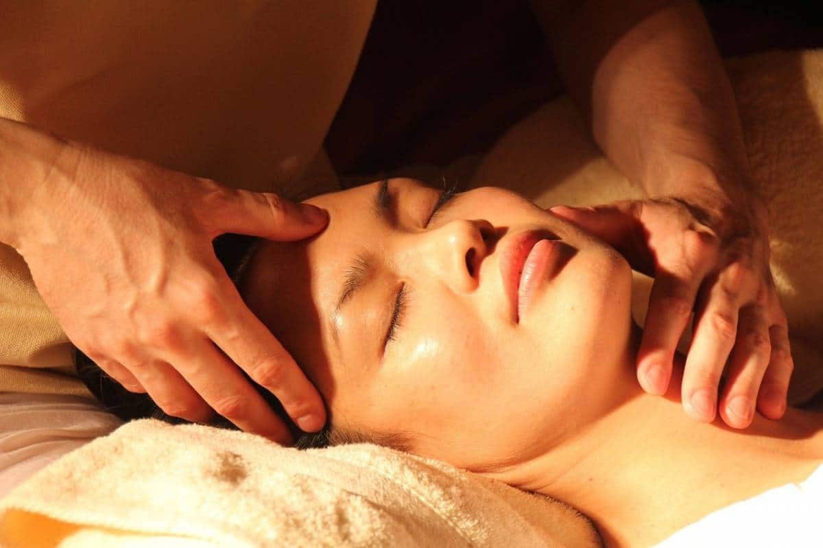 Une personne recevant un massage facial relaxant pour le bien-être.