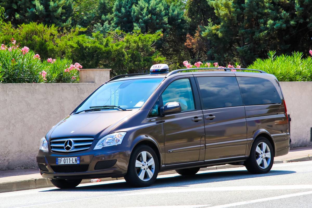 Un taxi minivan Mercedes-Benz garé sur le bord d'une route.