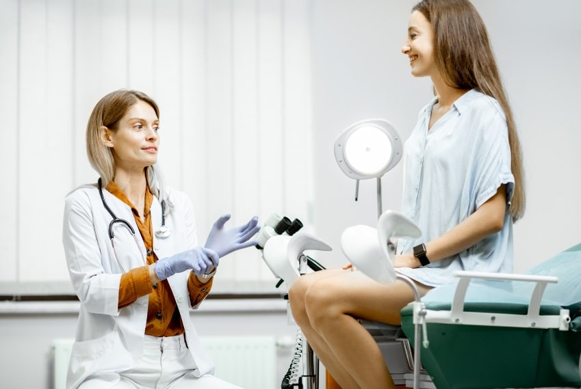 Médecin discutant avec un patient souriant lors d'une consultation médicale.