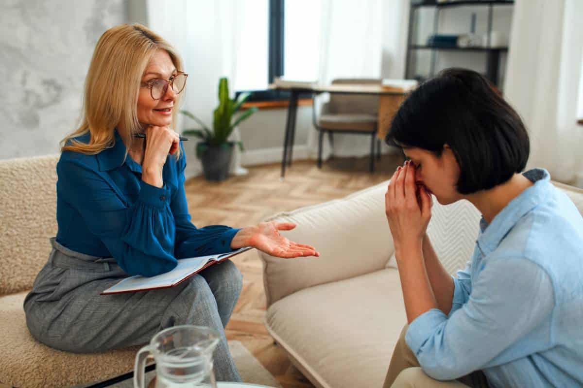 Un psychologue parle avec un patient en détresse pendant une séance de counseling en santé mentale.