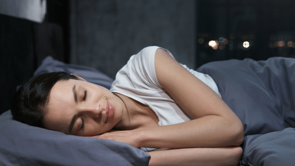 Une jeune femme ayant une nuit de sommeil parfaite dans son lit la nuit.
