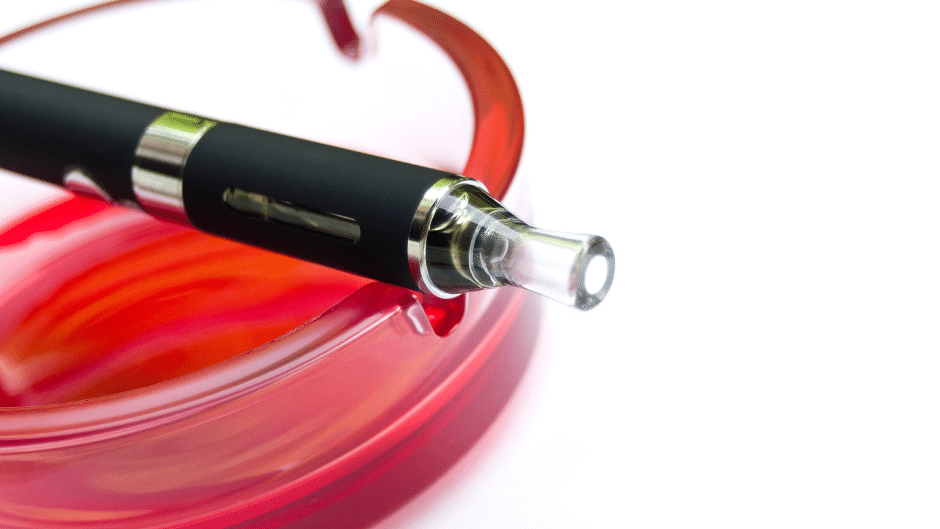 Une e-cigarette immergée dans un liquide rouge vibrant, spécialement adapté pour répondre à vos besoins.