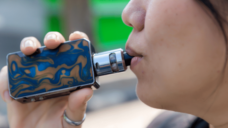 Une femme utilise une e-cigarette adaptée à ses besoins.
